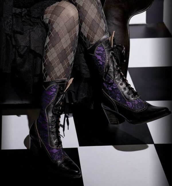 A woman is sitting on a checkered floor in a pair of Biddy Black Leather & Lace Purple Womens Granny Boots.