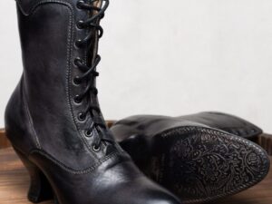 A pair of Eleanor Black Leather Womens Granny Boots on a wooden table.
