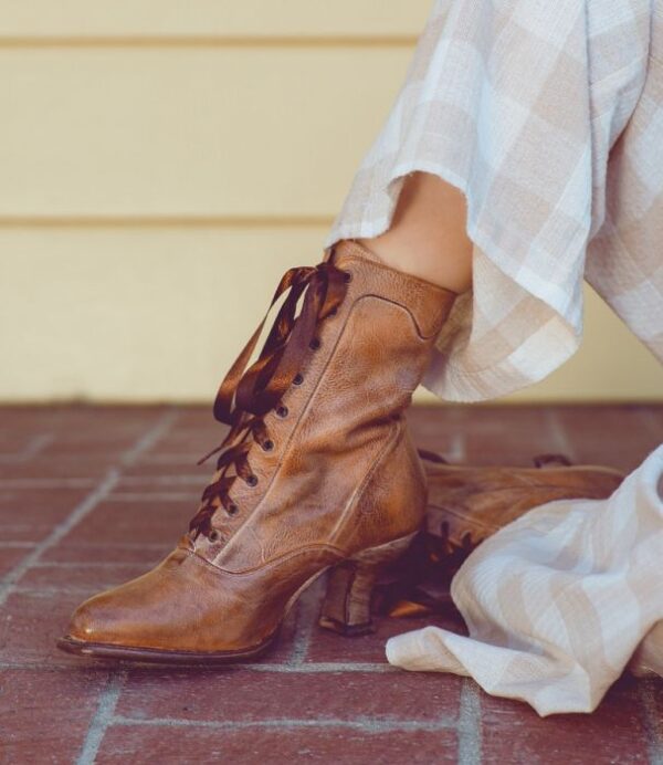 A woman wearing a pair of Eleanor Tan White Leather Womens Granny Boots.
