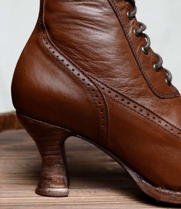A pair of Jasmine Cognac Kidskin Womens Granny Boots on top of a wooden table.