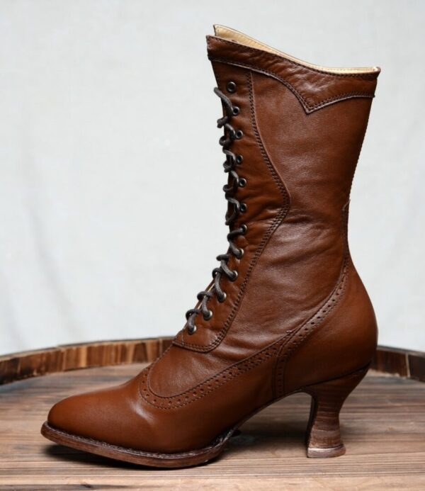 A pair of Jasmine Cognac Kidskin Womens Granny Boots on top of a barrel.