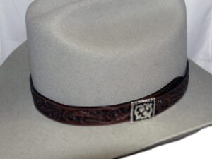 A light colored hat with a brown engraved band