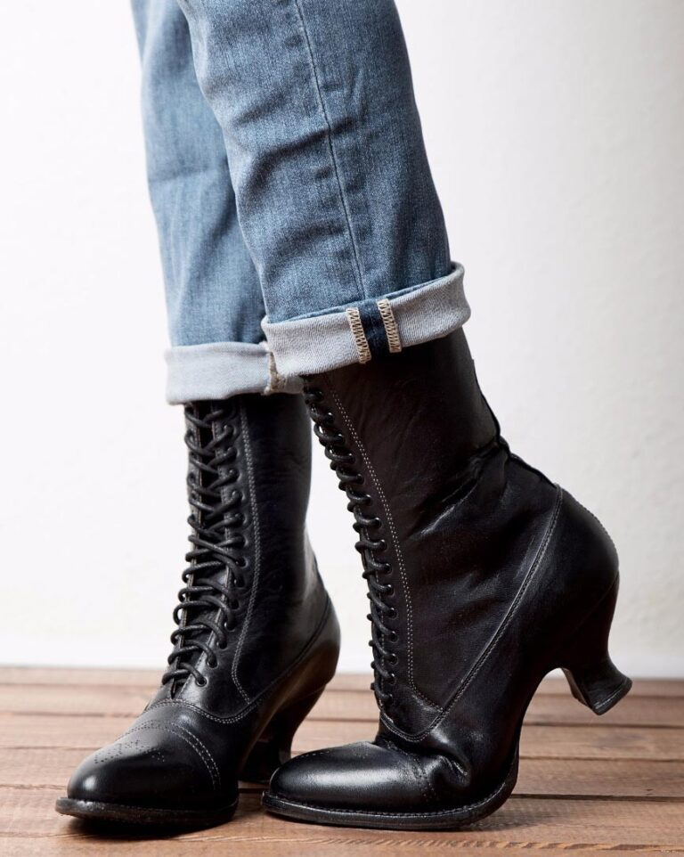 A woman wearing Mirabelle Black Leather Womens Granny Boots on a wooden floor.