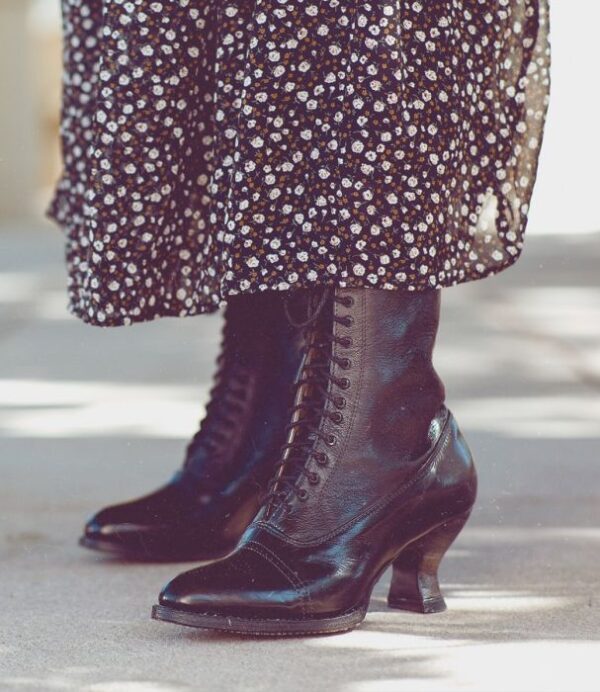 A woman wearing Mirabelle Black Leather Womens Granny Boots and a floral dress.