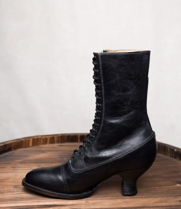 Mirabelle Black Leather Women's Granny Boots on top of a wooden barrel.