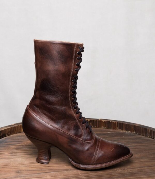 A pair of Mirabelle Teak Leather Womens Granny Boots on top of a wooden barrel.
