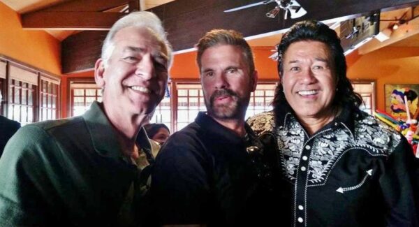 Three men wearing "Silver Gunfighter" mens silver embroidered black western shirts posing for a photo in a restaurant.