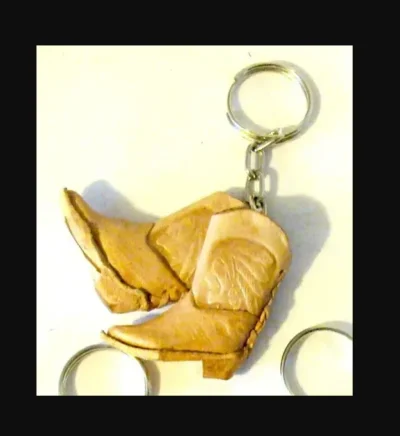 A keychain with a pair of leather double mini cowboy boots on it.