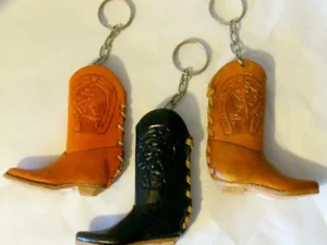 Three Ceramic Single Cowboy Boot Keychains on a white surface.