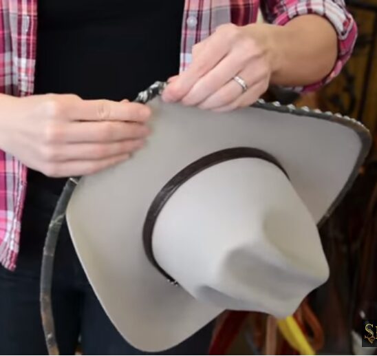 A man holding white cowboy hat
