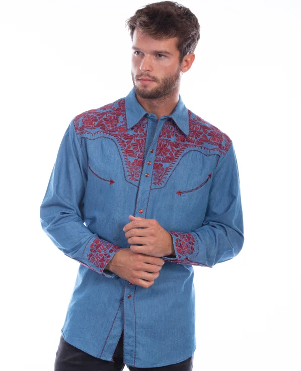 A man wearing a blue denim shirt with red embroidery, a "Cranberry Gunfighter" Mens Scully Embroidered Blue Cowboy Shirt.