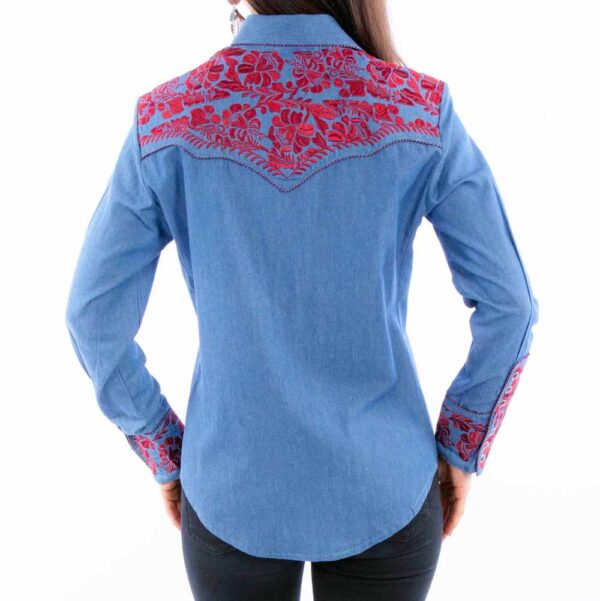 A woman showcasing the back view of her Scully Womens Cranberry Embroidered Blue Western Shirt featuring intricate red embroidery.
