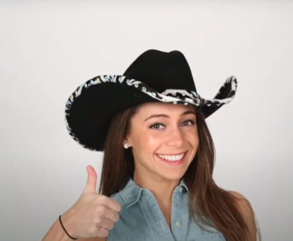 A girl in a Double Row Clear Rhinestone Bounded Edge with Matching Hat Band confidently giving a thumbs up for added style.