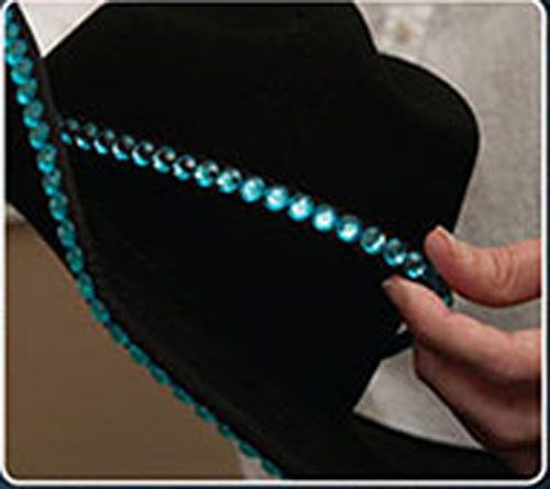 A person is embellishing a Double Row Clear Rhinestone Bounded Edge with Matching Hat Band with turquoise beads.