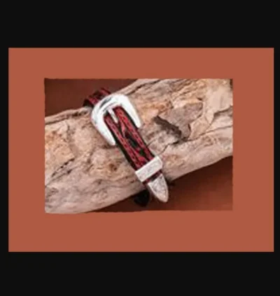 A Western Buckle Tooled Leather Bracelet with Rawhide on a piece of wood.
