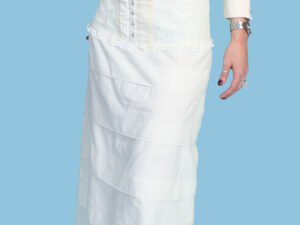 A woman wearing a Women's Ivory western prairie ruffle skirt and a white shirt.